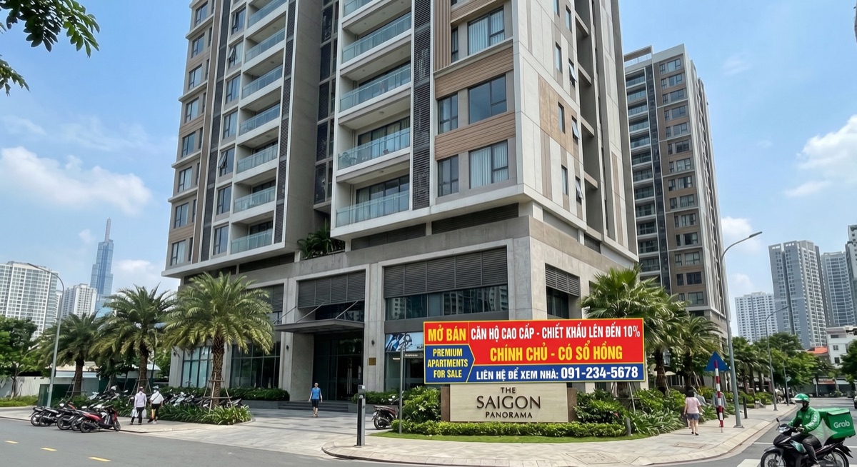 A modern apartment building in Ho Chi Minh City with a 'for sale' sign in Vietnamese